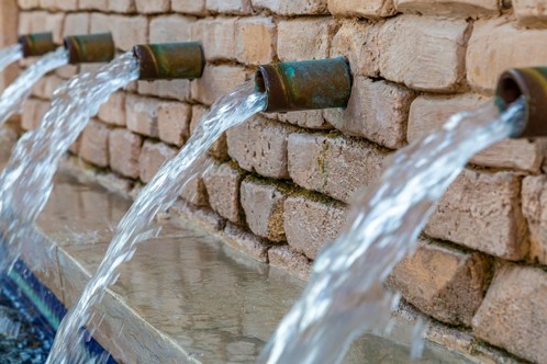 Wasser sprudelt aus Rohren